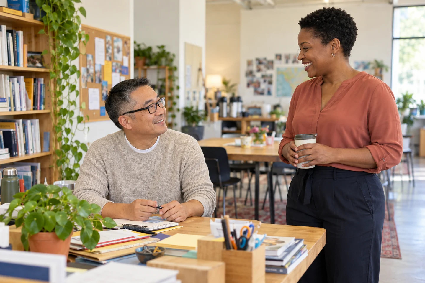 Nonprofit staff members sharing a relaxed conversation in a community education center.